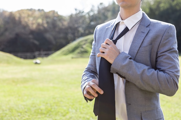 Foto gratuita primer plano de joven quitándose la corbata después de trabajar