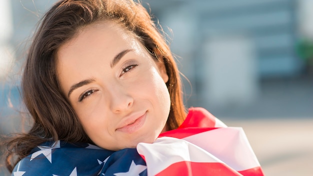 Primer plano joven sosteniendo la gran bandera de Estados Unidos