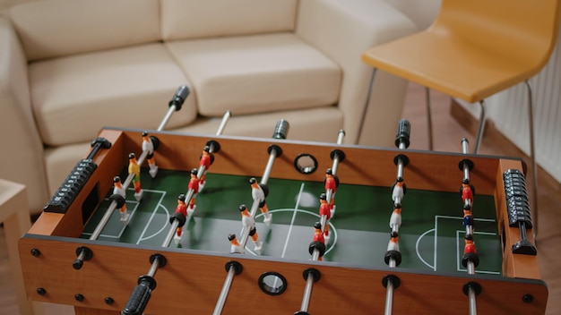 Primer plano del juego de futbolín y botellas de cerveza con bocadillos en la mesa para la celebración de fiestas con colegas después del trabajo en la oficina. Juguete para jugar al fútbol con jugadores y pelota para gol por diversión.