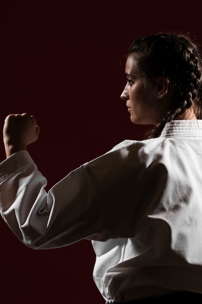 Primer plano de lado mujer en uniforme de karate blanco