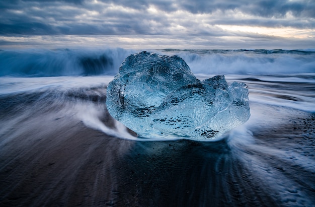 Primer plano de una laguna glaciar en Islandia con un mar ondulado en el fondo