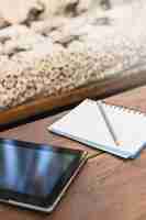 Foto gratuita primer plano de lápiz en el cuaderno con tableta digital en mesa de madera