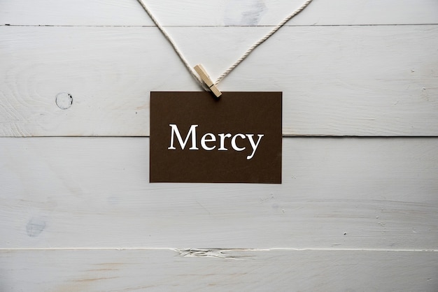 Foto gratuita primer plano de un letrero unido a una cuerda con misericordia escrito en él