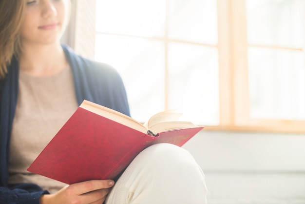 Primer plano de un libro de lectura de mujer en casa