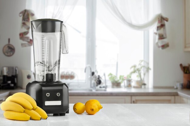 Primer plano de licuadora de alimentos de metal con frutas tropicales exóticas frescas junto a él en el fondo de la cocina con espacio vacío. Licuadora y mesa de madera en la cocina