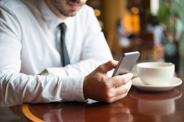 Primer plano de líder empresarial con Smartphone en el café