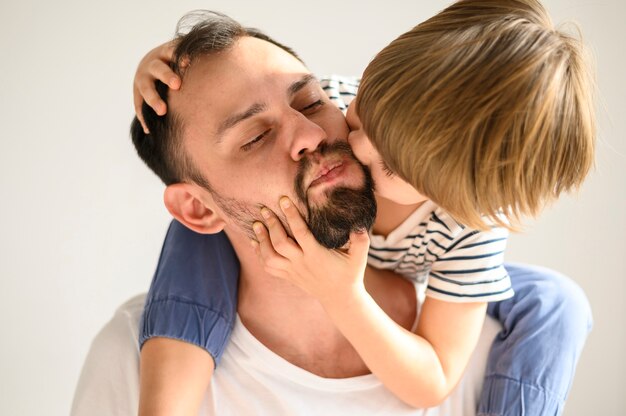 Primer plano lindo niño besando a hijo