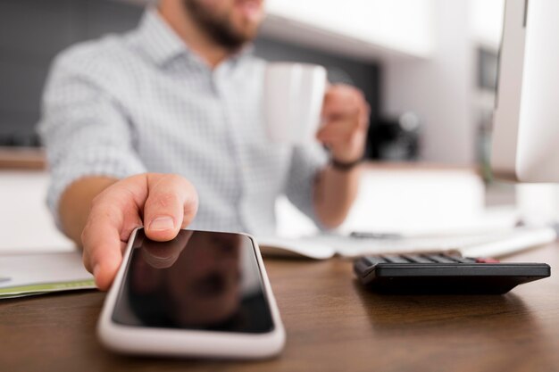 Primer plano macho adulto sosteniendo teléfono móvil