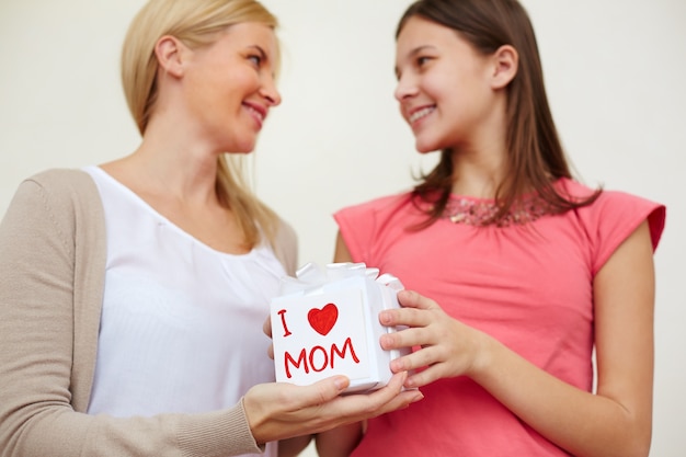 Primer plano de madre e hija sujetando el regalo