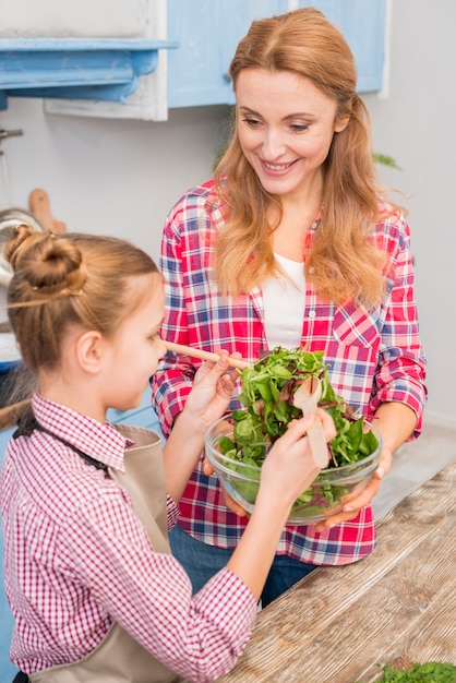 Primer plano de la madre y la hija preparando la ensalada