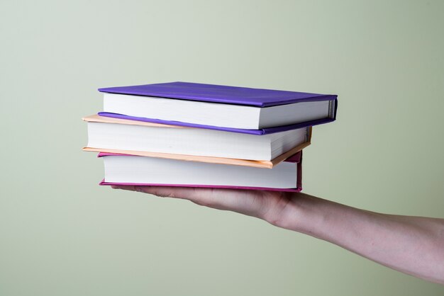 Primer plano de mano con algunos libros