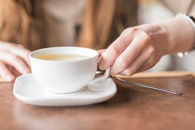 Primer plano de mano cogiendo una taza de té