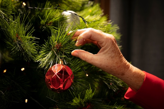 Foto gratuita primer plano de la mano configurando el árbol de navidad