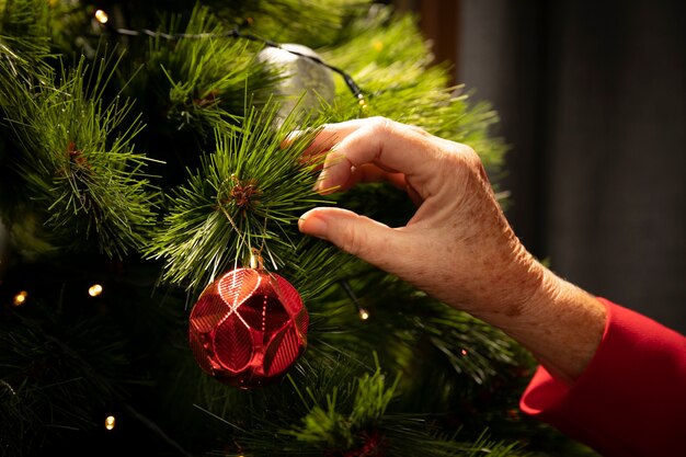 Primer plano de la mano configurando el árbol de navidad