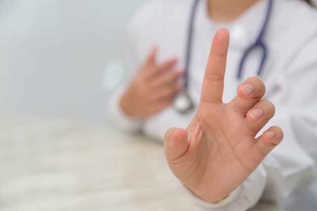 Primer plano de la mano de una doctora mostrando su dedo índice