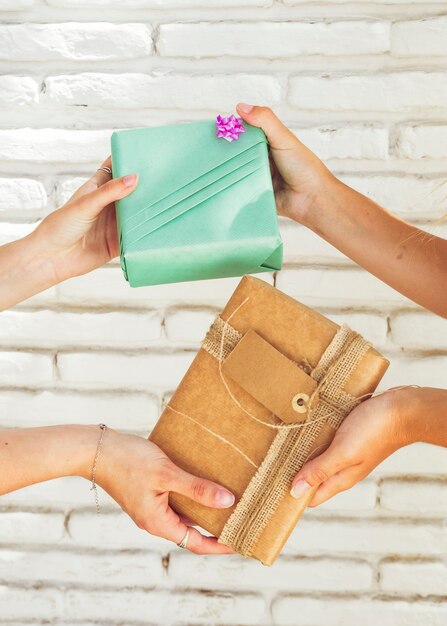 Primer plano de la mano de dos mujeres sosteniendo regalos