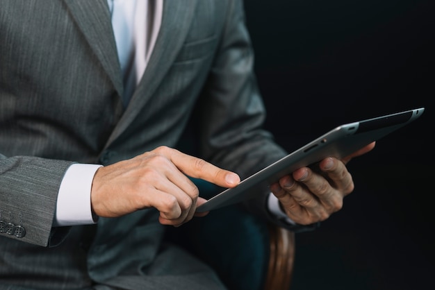 Primer plano de la mano de un empresario tocando la pantalla de la tableta digital