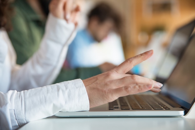 Primer plano de una mano femenina escribiendo en el teclado