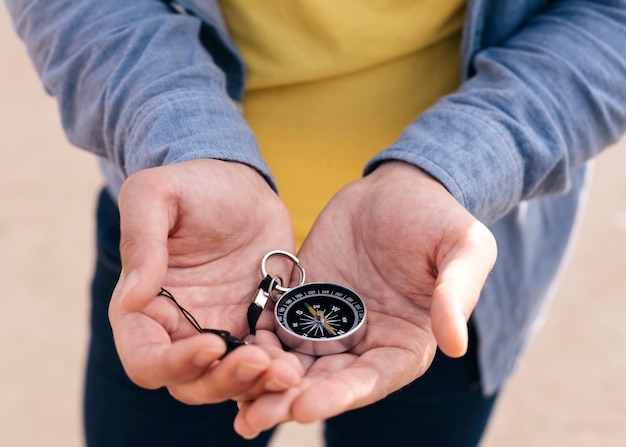 Primer plano de la mano del hombre con brújula de navegación