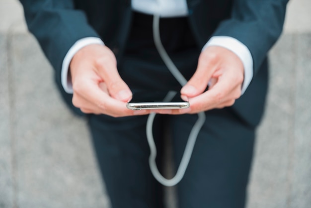 Foto gratuita primer plano de la mano de un hombre de negocios mediante teléfono móvil