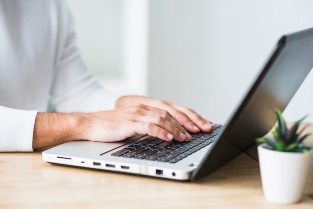 Primer plano de la mano de un hombre de negocios trabajando en la computadora portátil