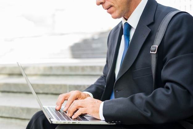 Foto gratuita primer plano de la mano de un hombre de negocios usando laptop