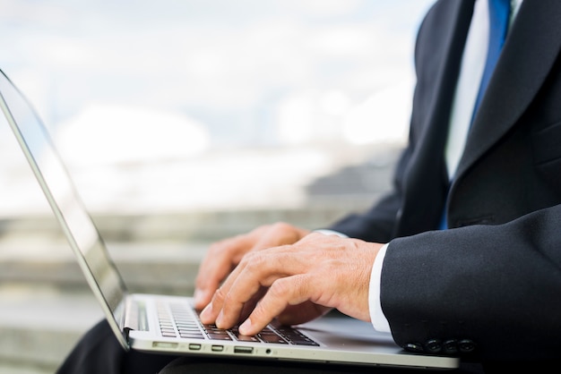 Primer plano de la mano de un hombre de negocios usando laptop