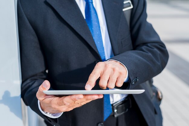Primer plano de la mano de un hombre de negocios usando tableta digital
