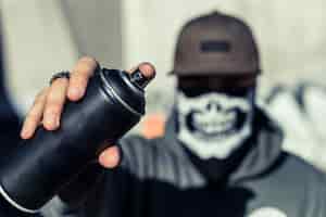 Foto gratuita primer plano de la mano de un hombre que sostiene aerosol negro puede