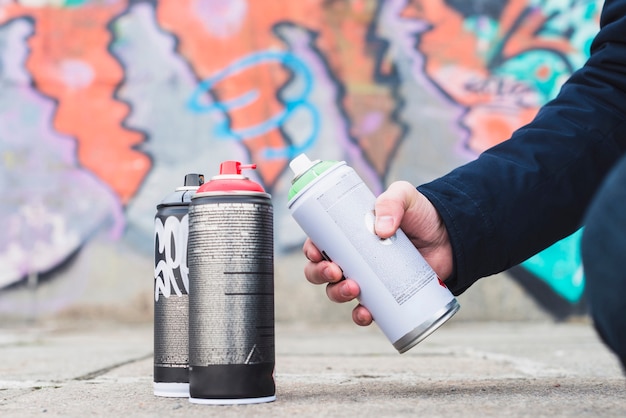 Primer plano de la mano del hombre que sostiene la botella de spray