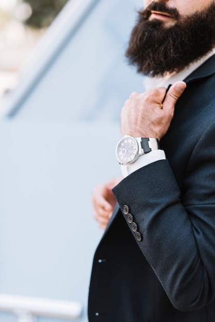 Primer plano de la mano del hombre con un reloj de pulsera.