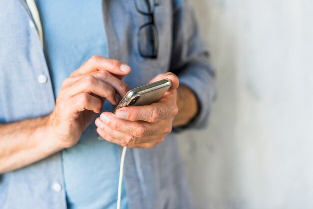 Primer plano de la mano del hombre con teléfono móvil