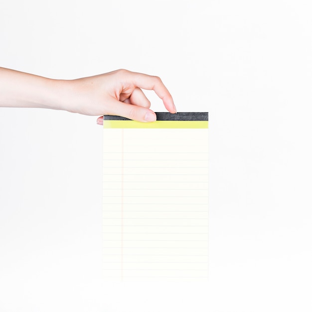 Primer plano de una mano humana con bloc de notas en blanco