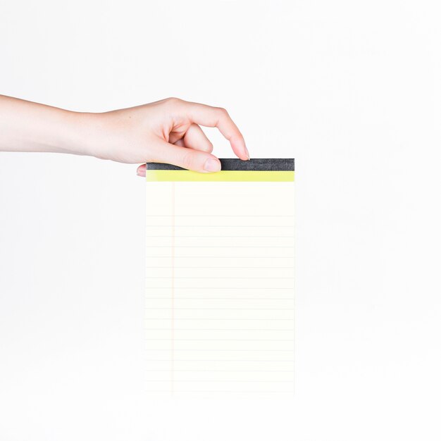 Primer plano de una mano humana con bloc de notas en blanco