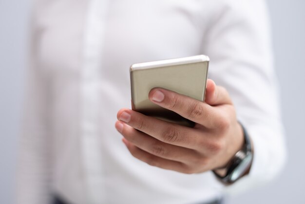 Primer plano de mano masculina sosteniendo teléfono móvil