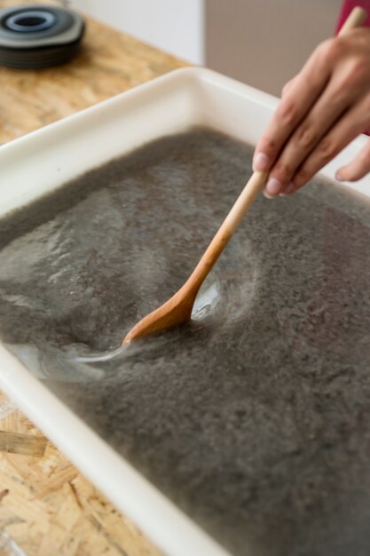 Primer plano, de, mano de mujer, agitar, papel, pulpa