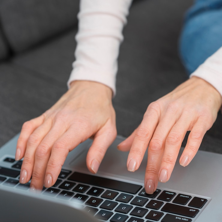 Foto gratuito primer plano de la mano de la mujer escribiendo en la computadora portátil