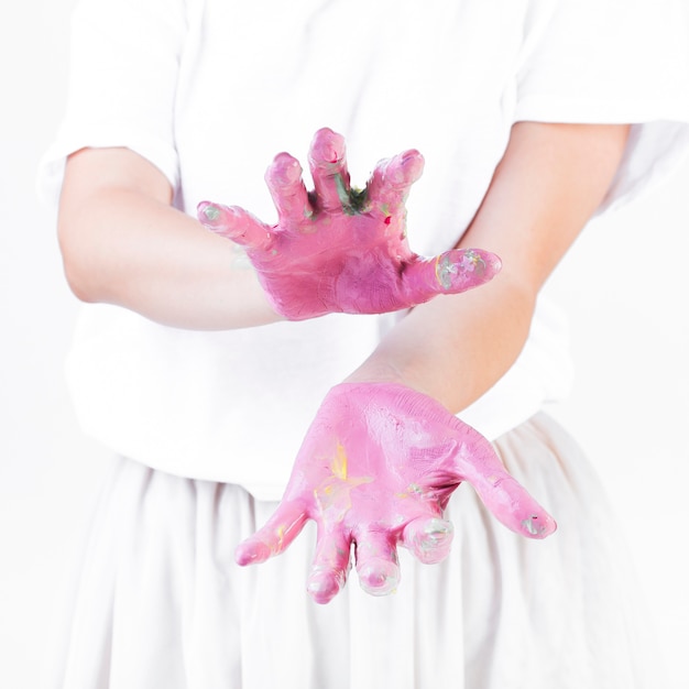 Primer plano de la mano de una mujer gesticulando con pintura rosa