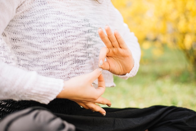 Primer plano de mano de mujer con gesto de gyan mudra durante yoga