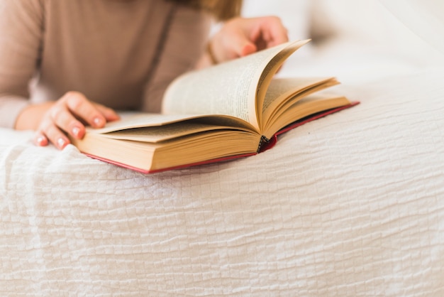 Primer plano de mano de mujer girando páginas de libro