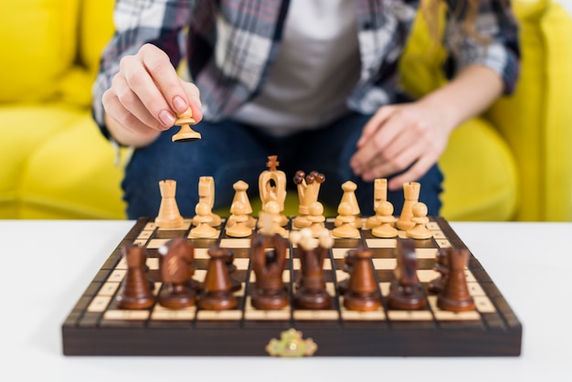 Primer plano de la mano de la mujer jugando al ajedrez