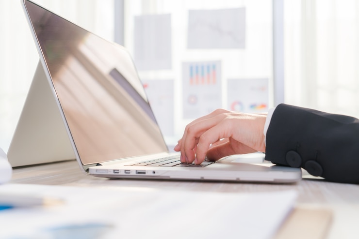 Foto gratuito primer plano de la mano de una mujer de negocios escribiendo en el teclado de un portátil