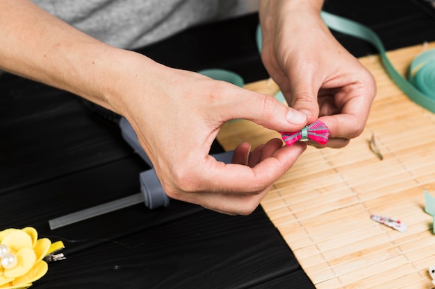 Primer plano de la mano de la mujer con pinza de pelo rosa