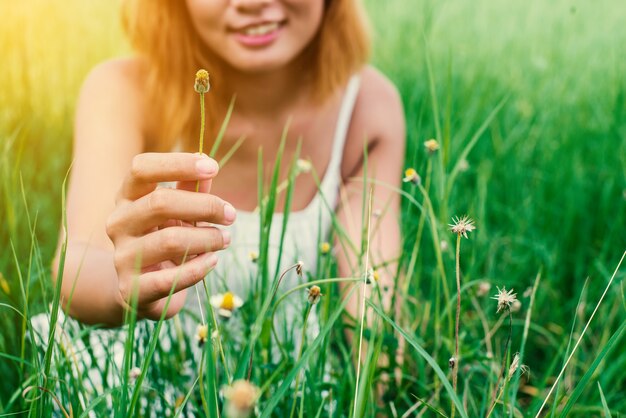 Primer plano de la mano de la mujer que sostiene una flor