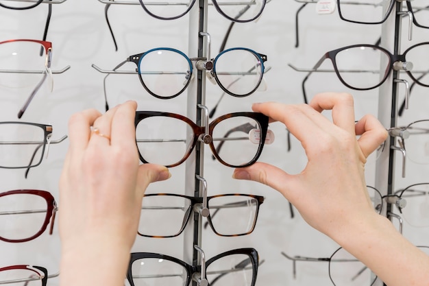 Primer plano de mano de mujer quitando anteojos de la pantalla