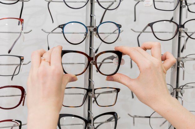 Primer plano de mano de mujer quitando anteojos de la pantalla