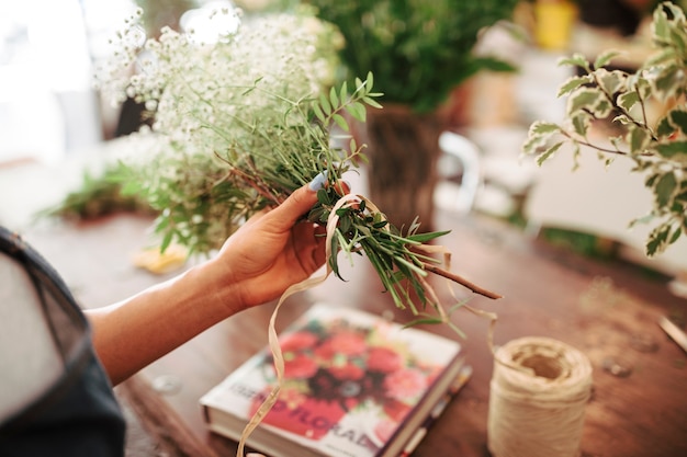 Primer plano de la mano de una mujer con ramo de flores blancas frescas