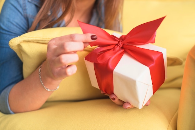 Primer plano de la mano de una mujer con regalo de cumpleaños