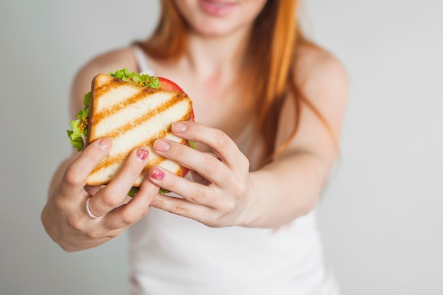 Primer plano de la mano de la mujer con sandwich casero a la parrilla