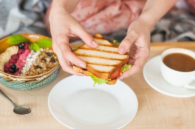 Primer plano de la mano de la mujer con sandwich